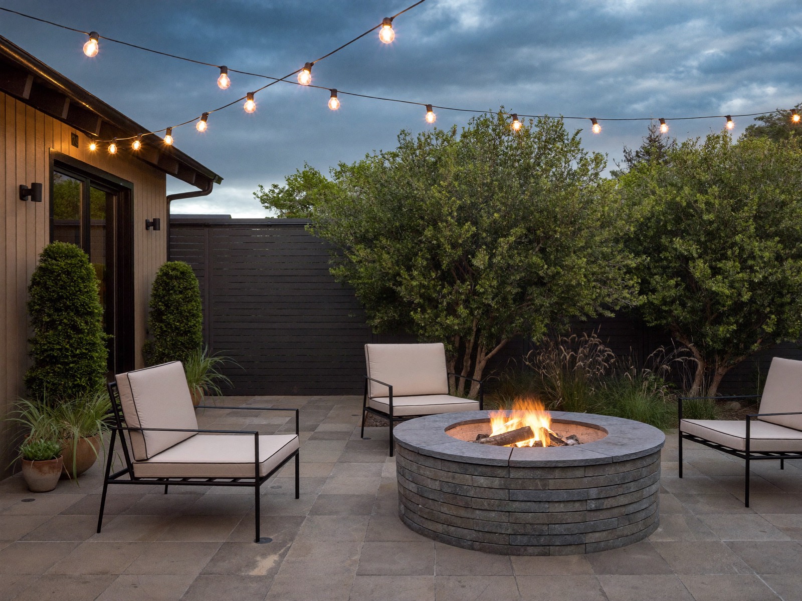 Paver patio with a stone fire pit and lounge seating in a Bay Area backyard
